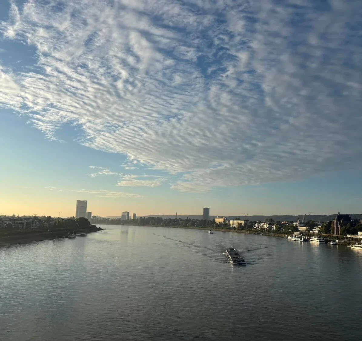 Blick auf den Rhein in Köln bei Sonnenaufgang, Symbol für Klarheit und einen neuen rauchfreien Start durch Hypnose.
